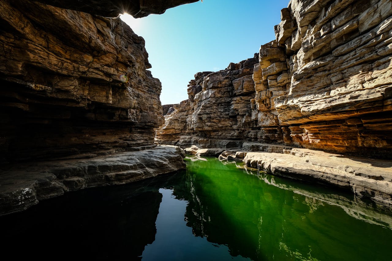 A green pool in a canyon with rocks